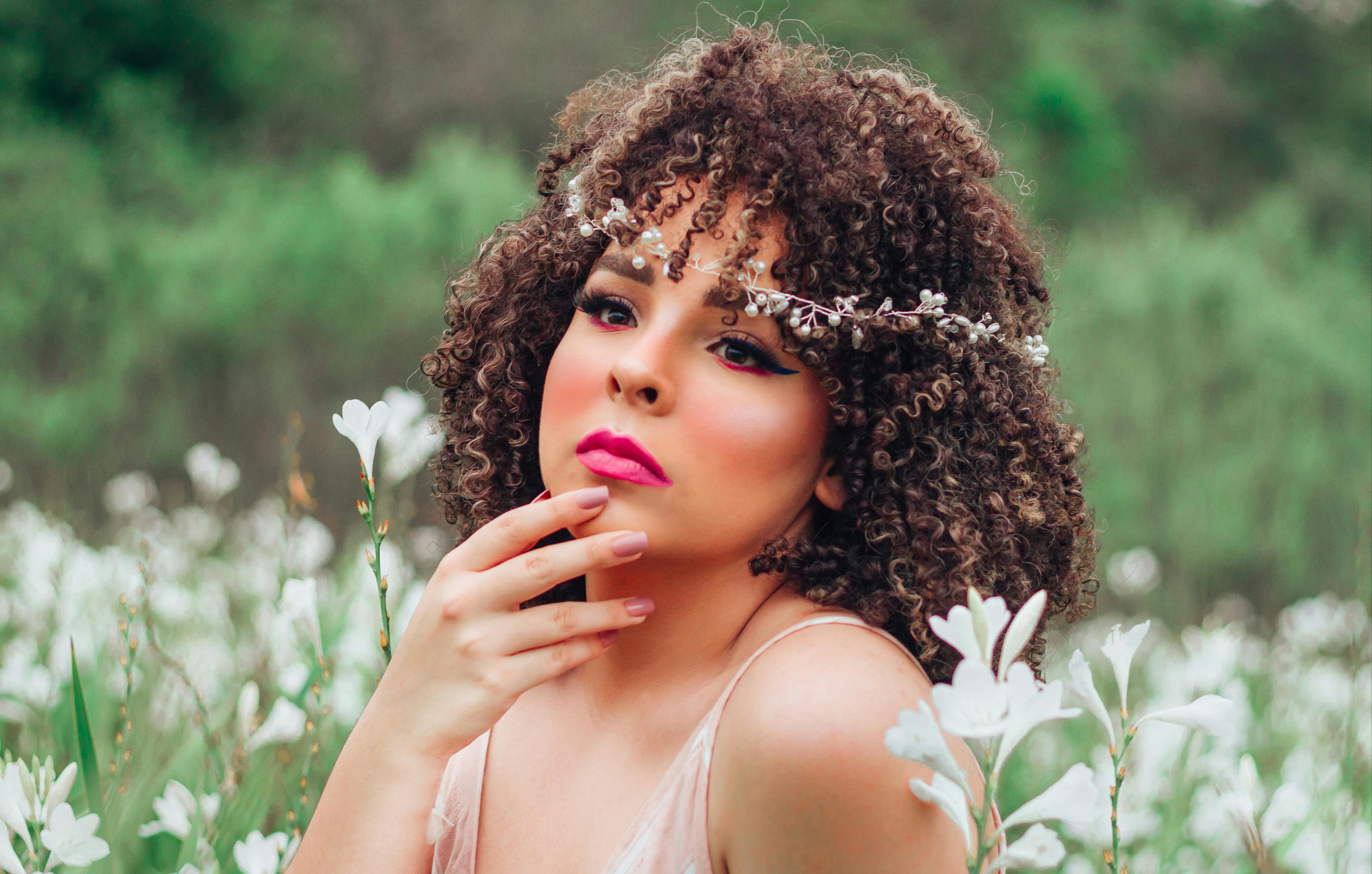 Жінка з посмішкою малює аквареллю за столом